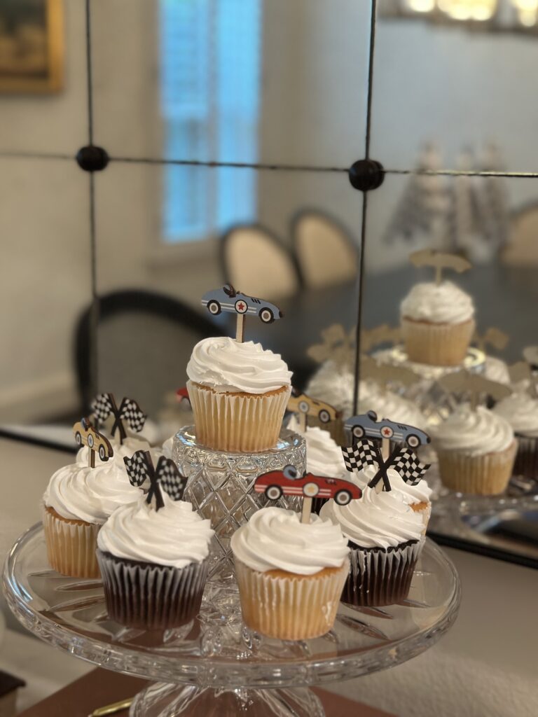 Cupcakes topped with illustrated vintage race cars and checkered flag picks.