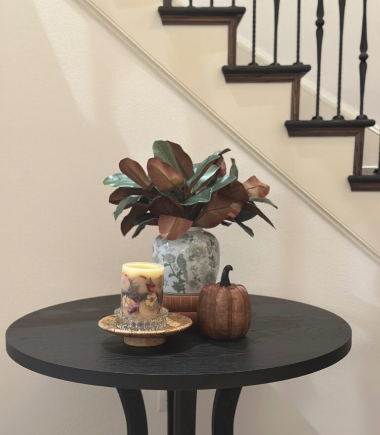 Fall entryway vignette with a floral ginger jar, spiced apple pillar candle, and wood pumpkin
